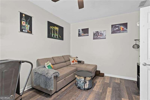 living room with ceiling fan and dark wood-type flooring