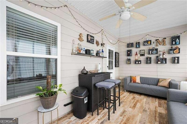 living room featuring light hardwood / wood-style floors and wooden walls