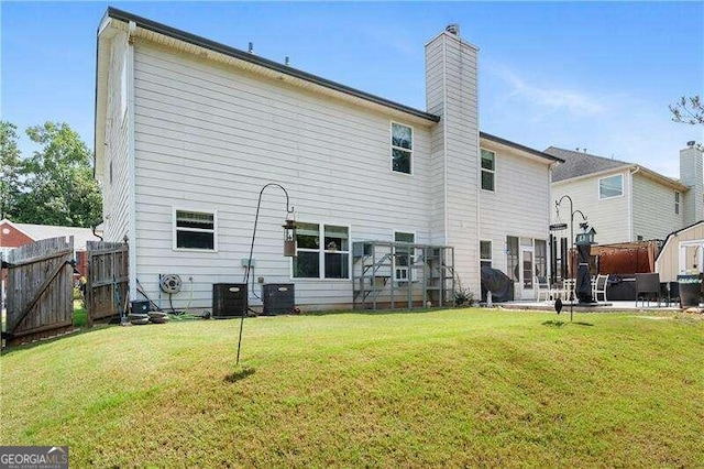 back of house with a yard, central AC unit, and a patio area