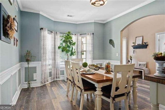 dining area with wood-type flooring and crown molding