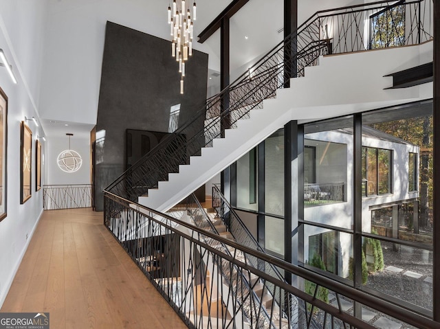 interior space with a chandelier, a high ceiling, and hardwood / wood-style floors