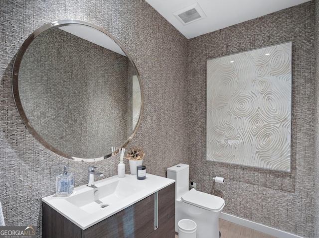 bathroom featuring toilet, vanity, and hardwood / wood-style flooring