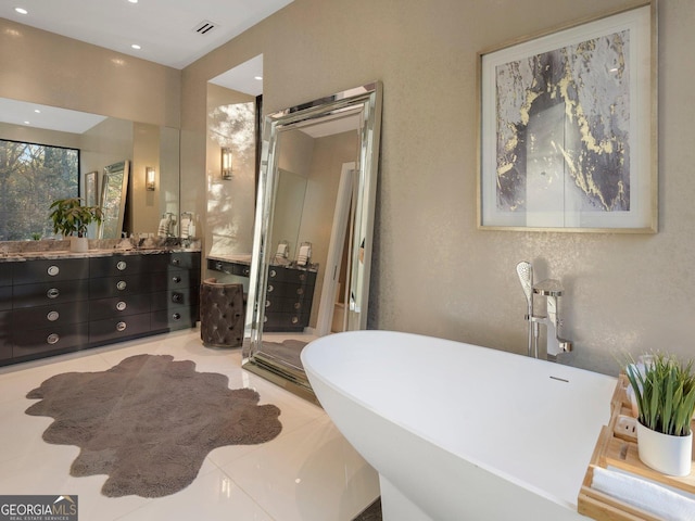 bathroom with tile patterned flooring, vanity, and a bath