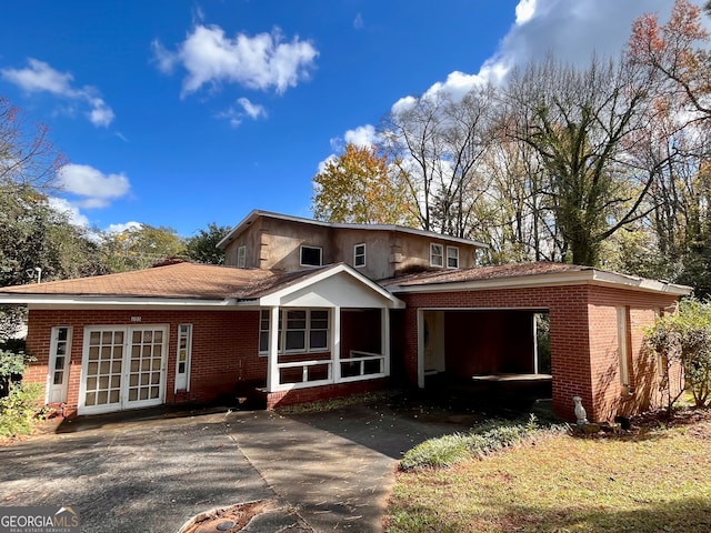 view of front of home with french doors and a carport