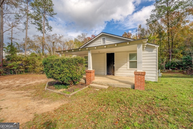 bungalow with covered porch and a front lawn