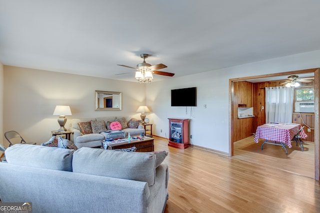 living room featuring ceiling fan, cooling unit, and light hardwood / wood-style flooring