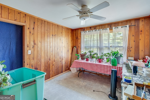 interior space featuring wooden walls and ceiling fan