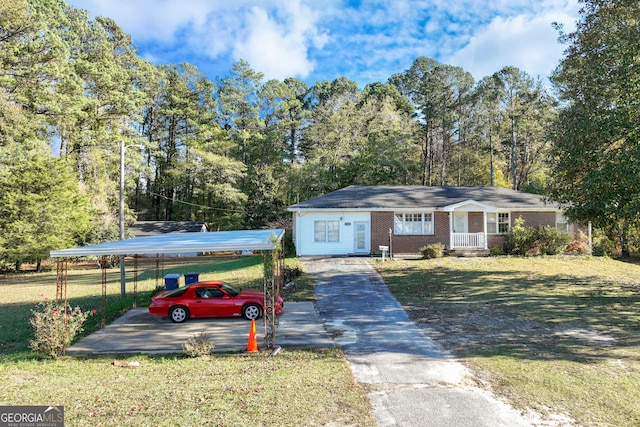 ranch-style home with covered porch, a front yard, and a carport