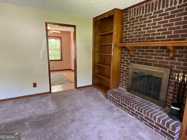 unfurnished living room featuring a brick fireplace, carpet, and a textured ceiling