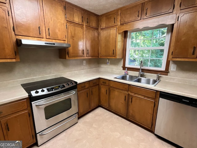 kitchen with sink, a textured ceiling, and appliances with stainless steel finishes