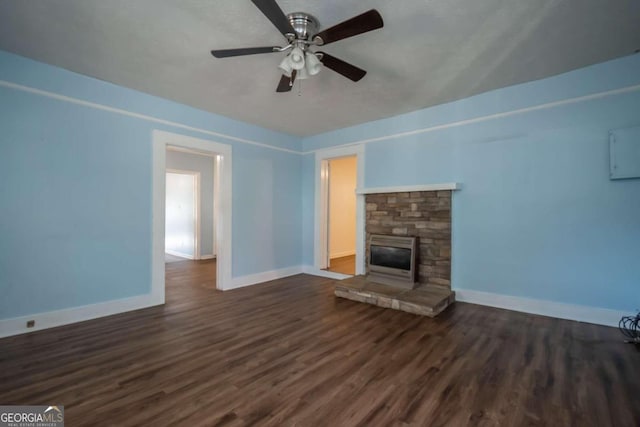 unfurnished living room with dark hardwood / wood-style floors, ceiling fan, and a fireplace