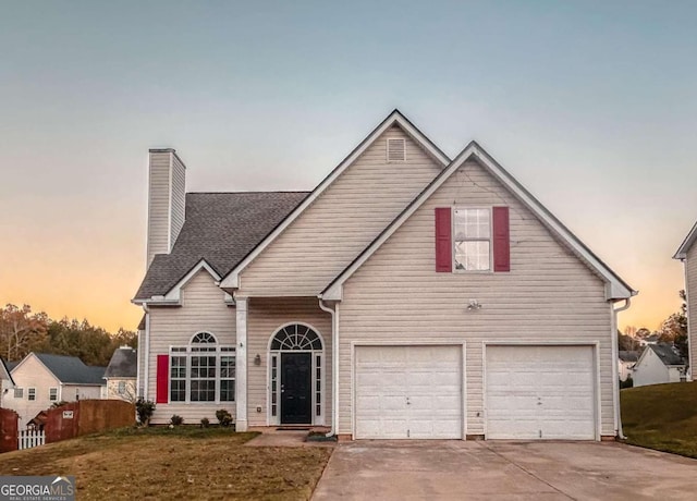 view of front of home featuring a garage and a lawn