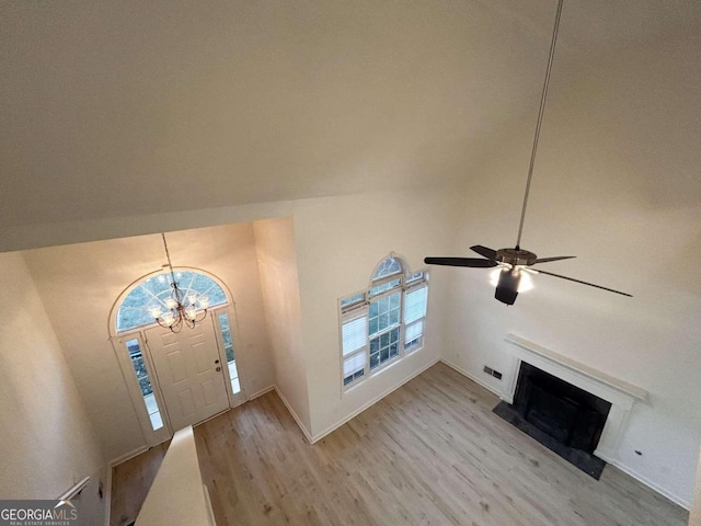 entryway with high vaulted ceiling, ceiling fan with notable chandelier, and light wood-type flooring