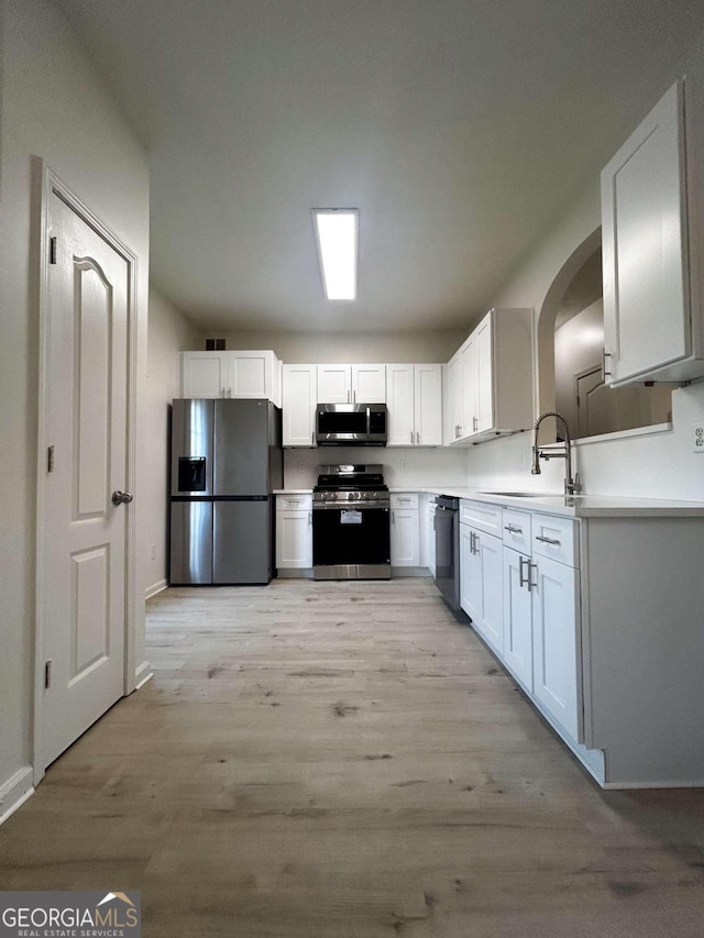 kitchen featuring light hardwood / wood-style floors, sink, white cabinetry, and stainless steel appliances