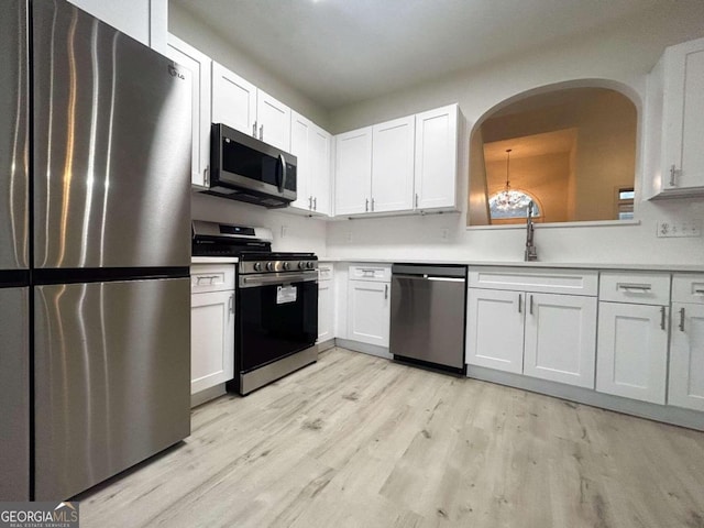 kitchen with white cabinetry, sink, stainless steel appliances, and light hardwood / wood-style floors