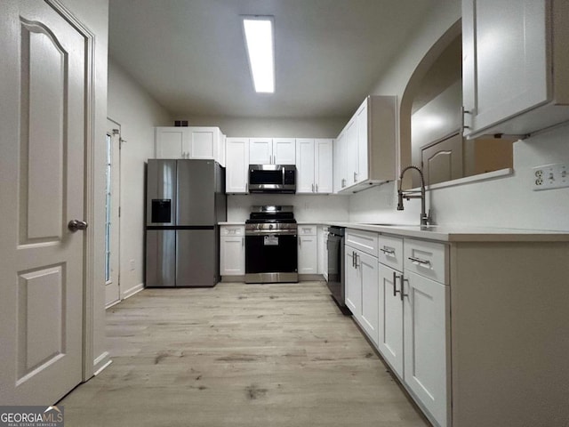 kitchen featuring light hardwood / wood-style floors, white cabinetry, sink, and appliances with stainless steel finishes