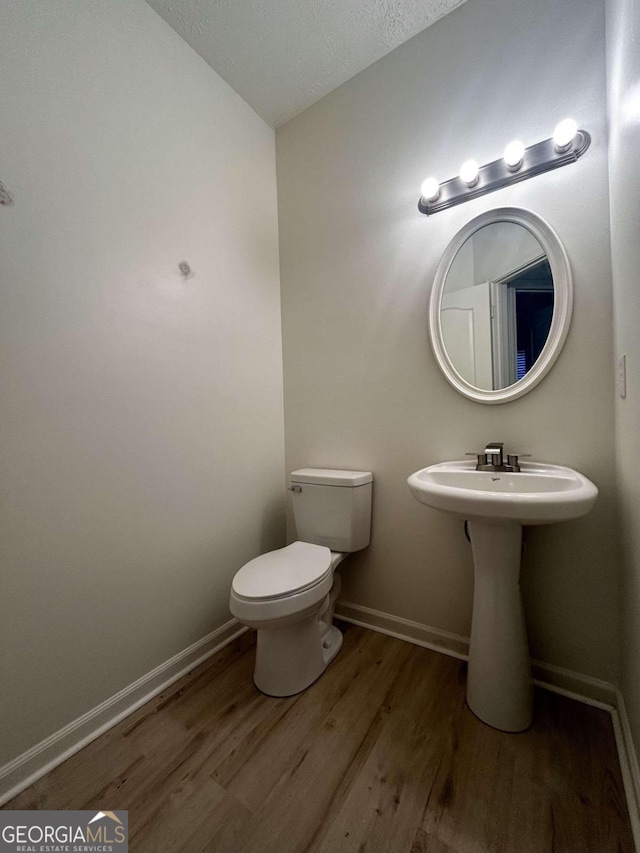 bathroom with hardwood / wood-style floors and toilet