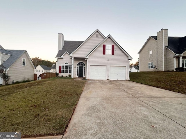 view of property with a garage and a lawn