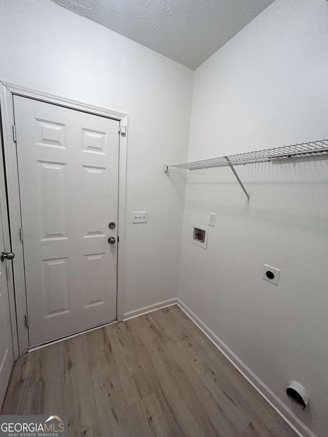 washroom featuring hardwood / wood-style floors, hookup for an electric dryer, a textured ceiling, and washer hookup