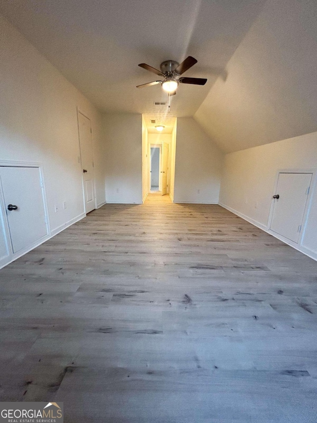 additional living space featuring ceiling fan, light hardwood / wood-style floors, and vaulted ceiling