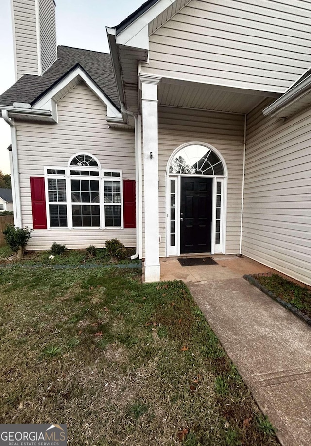 property entrance featuring a lawn