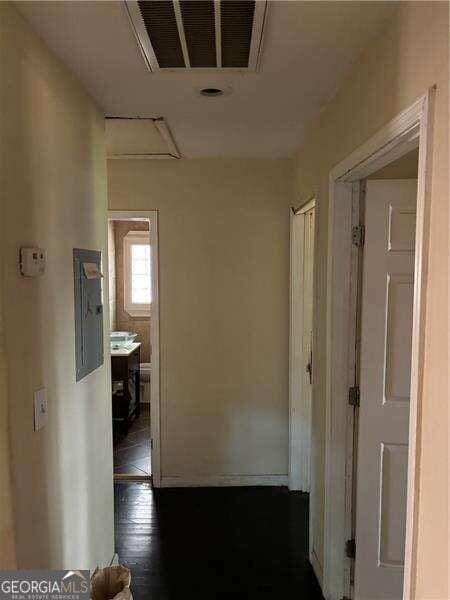 corridor featuring electric panel and dark hardwood / wood-style floors