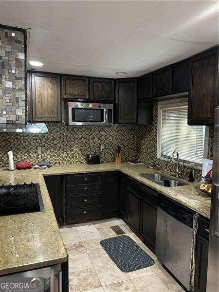 kitchen featuring decorative backsplash, appliances with stainless steel finishes, dark brown cabinetry, and sink