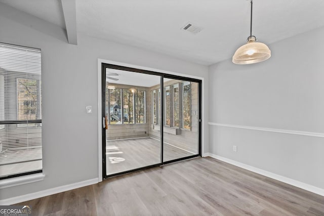 unfurnished room with beam ceiling and hardwood / wood-style flooring