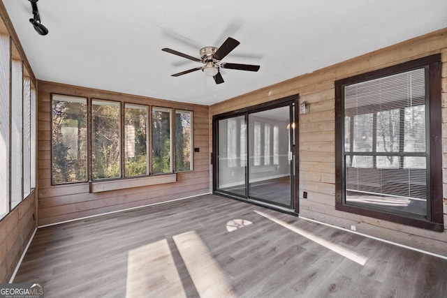 unfurnished sunroom with ceiling fan