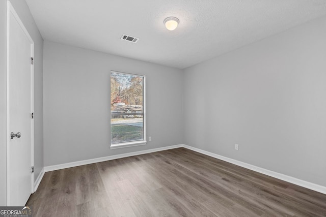 unfurnished room featuring hardwood / wood-style floors and a textured ceiling