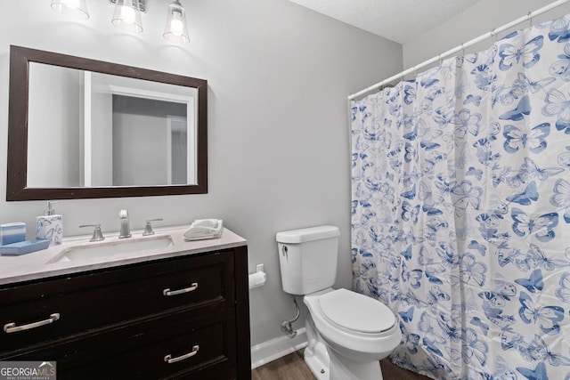 bathroom with vanity, toilet, a textured ceiling, walk in shower, and wood-type flooring