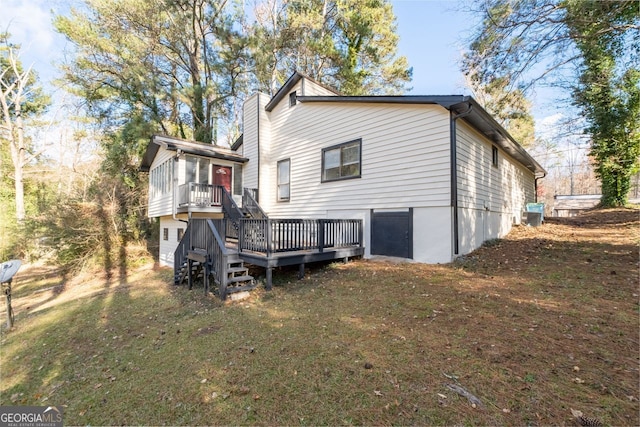 back of property with a lawn and a wooden deck