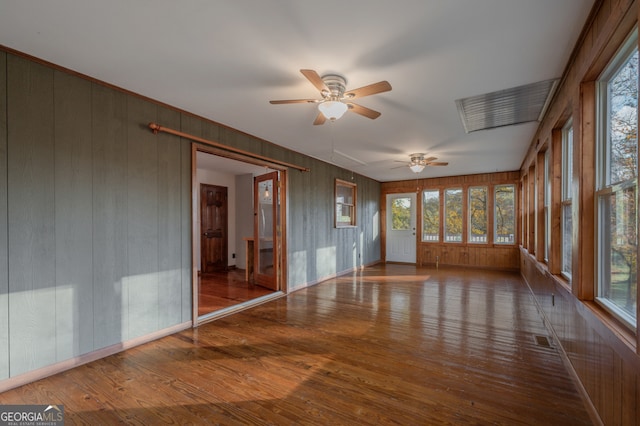 unfurnished sunroom featuring a wealth of natural light and ceiling fan