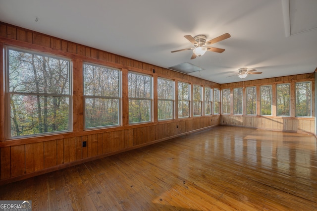 unfurnished sunroom featuring ceiling fan and a healthy amount of sunlight