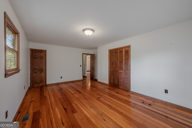 unfurnished bedroom featuring a closet and light hardwood / wood-style floors