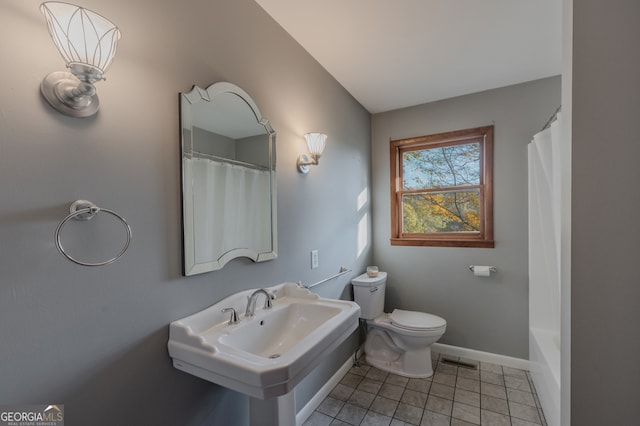 bathroom with tile patterned flooring, curtained shower, toilet, and sink