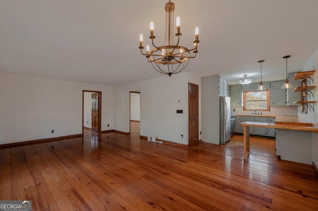 63 Bigham Rd, Trion, GA 30753 - unfurnished living room with a chandelier, a sink, hardwood / wood-style flooring, and baseboards