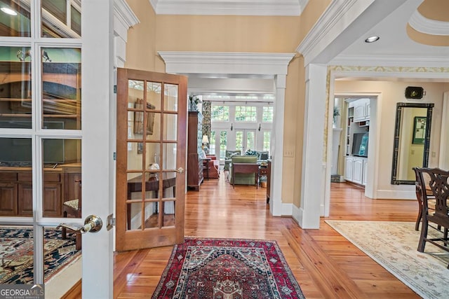 hallway with french doors, light wood-type flooring, and ornamental molding