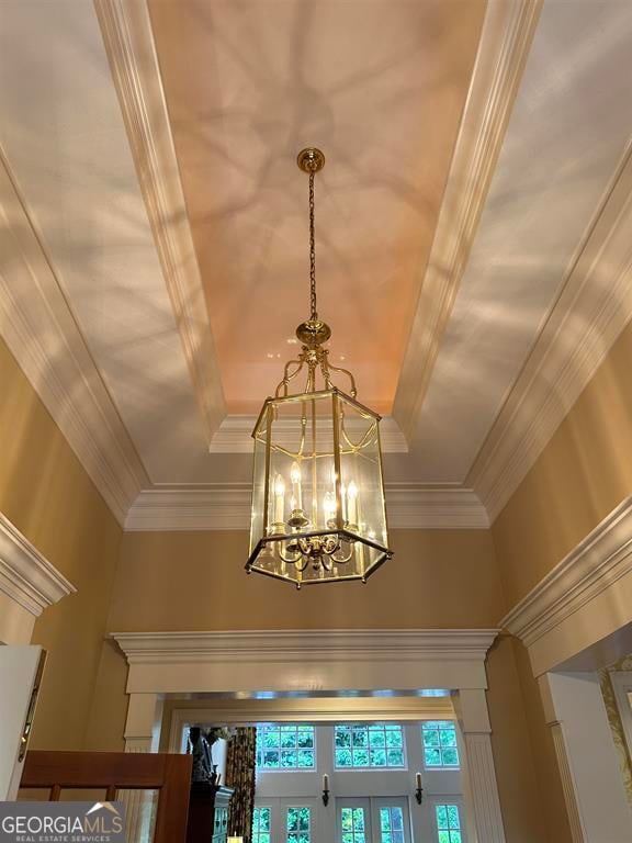 interior details with french doors, an inviting chandelier, and crown molding