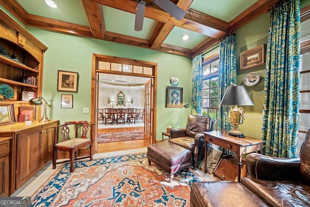 sitting room with beam ceiling, ceiling fan, coffered ceiling, light hardwood / wood-style flooring, and crown molding