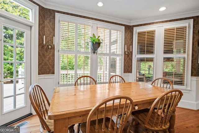 dining space with a healthy amount of sunlight, light hardwood / wood-style floors, and crown molding