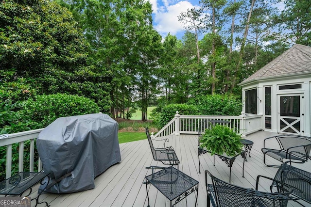 wooden deck featuring a grill