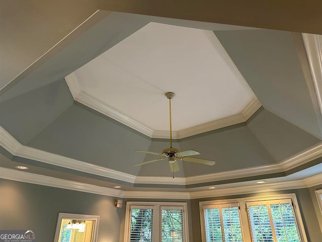 room details with a tray ceiling, ceiling fan, and ornamental molding