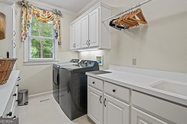 clothes washing area with washing machine and clothes dryer, sink, cabinets, and ornamental molding