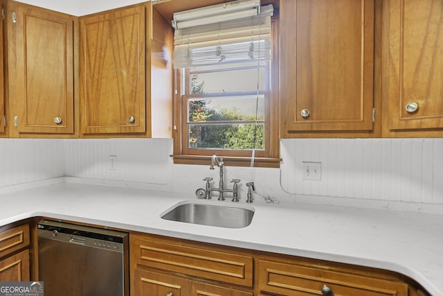 kitchen with light stone countertops, sink, and stainless steel dishwasher