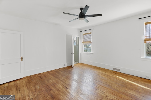 spare room with hardwood / wood-style flooring, a wealth of natural light, and ceiling fan