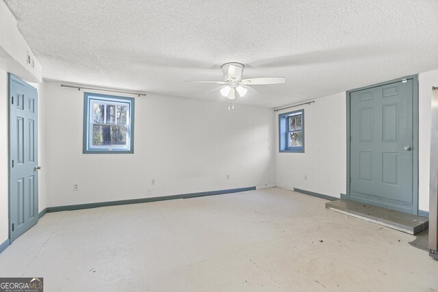 empty room featuring ceiling fan and a textured ceiling