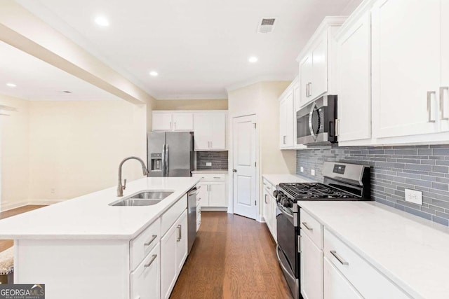 kitchen with dark hardwood / wood-style floors, white cabinetry, a kitchen island with sink, and appliances with stainless steel finishes