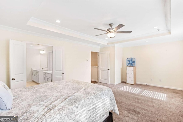 carpeted bedroom with ceiling fan, a raised ceiling, ornamental molding, and sink