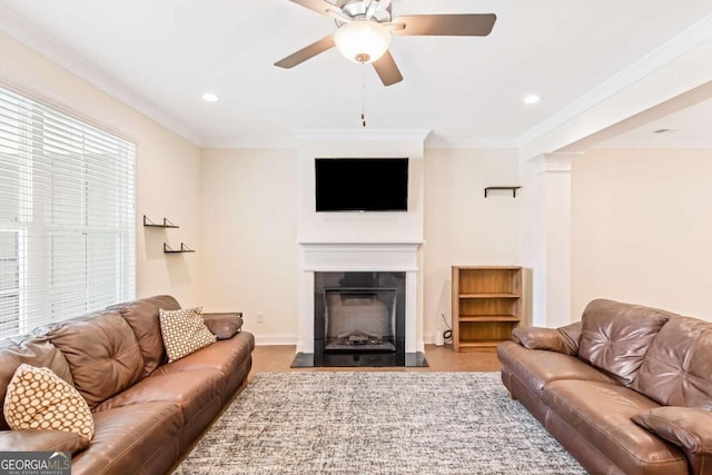 living room with ceiling fan and crown molding